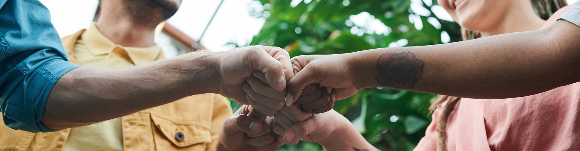 group of men and women collectively bringing there hands together symbolizing a partnership and agreement