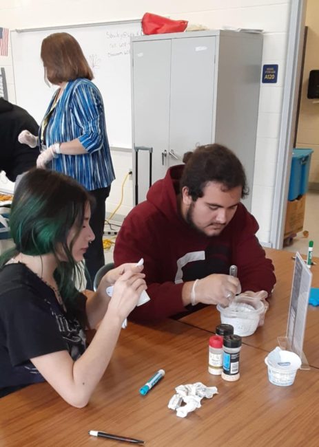 Youth making healthy dip for chicken nuggets.