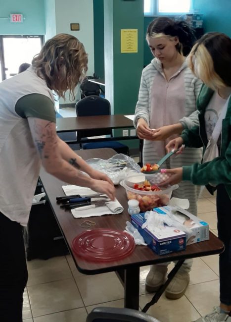 Nutrition Educator helps youth put ingredients together.