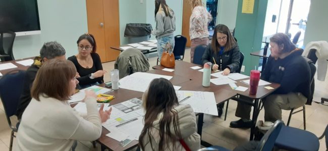 Table discussion between Extension Nutrition Educators, school staff, youth and community nonprofit about what food can be added to bags handed out to people who are unhoused.