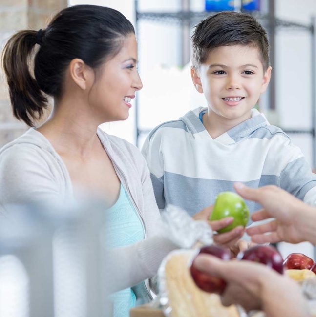 young mom and pre-school boy discussing the apple and healthy food choices.